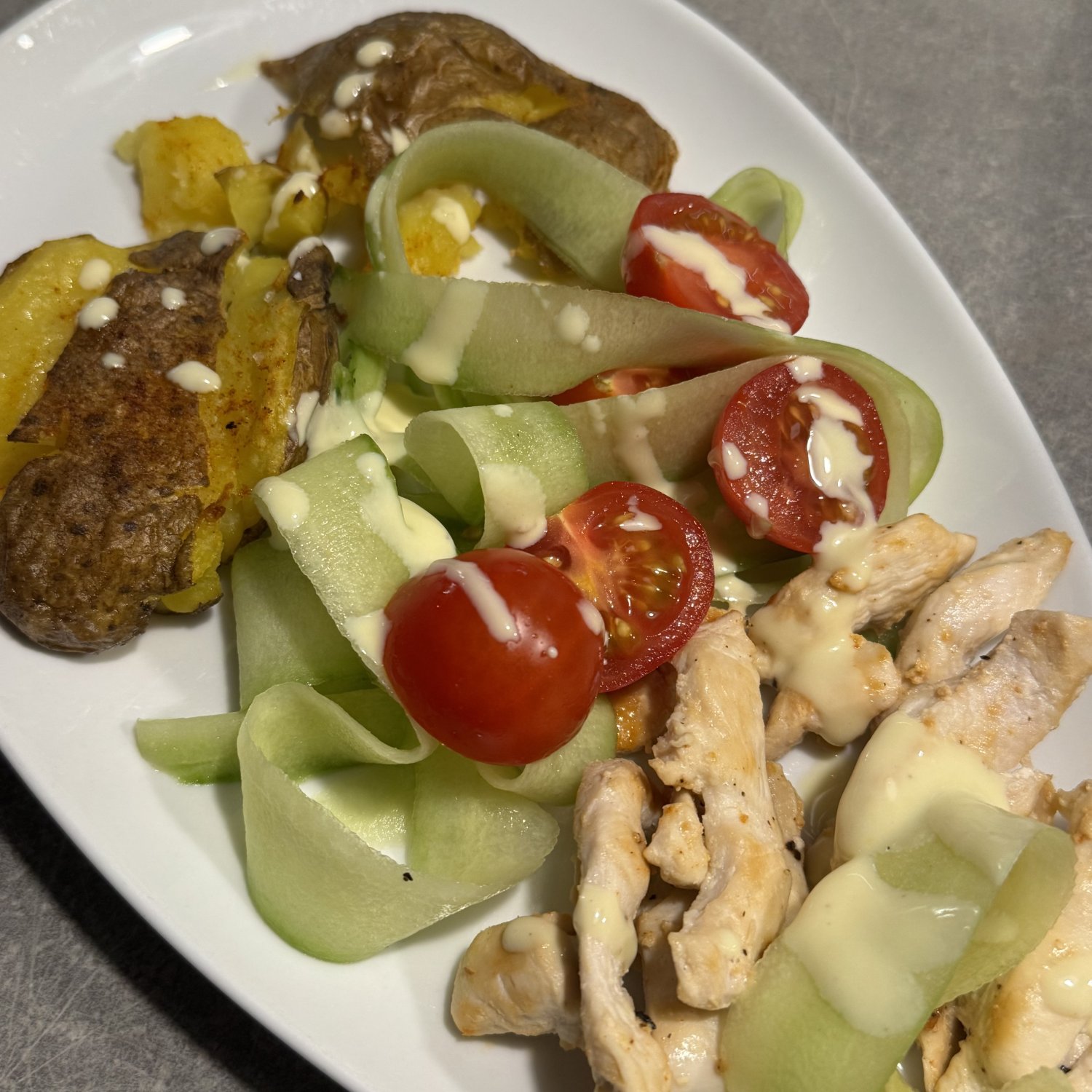 Rezept: Hähnchenstreifen mit Smashed Potatoes und Gurken-Tomaten-Salat